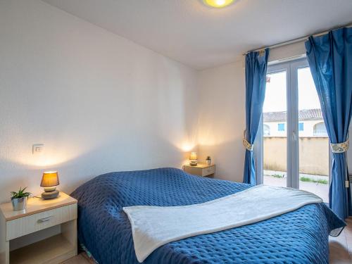 une chambre avec un lit bleu et une fenêtre dans l'établissement Apartment Port Quiétude-1 by Interhome, à Fréjus