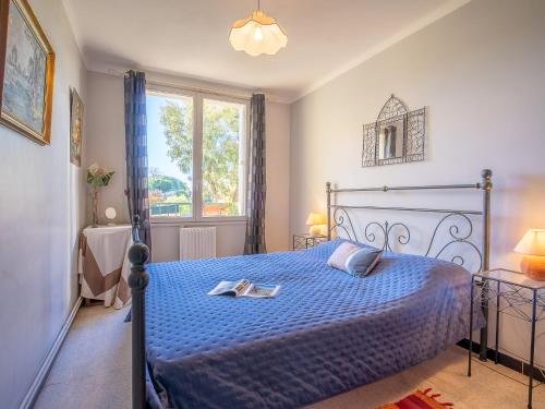 une chambre avec un lit bleu et une fenêtre dans l'établissement Apartment Le Grand Parc by Interhome, à Fréjus
