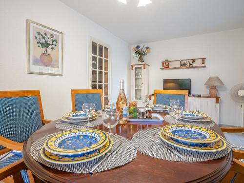 una mesa de comedor con platos y vasos. en Holiday Home Les Troenes by Interhome en Fréjus