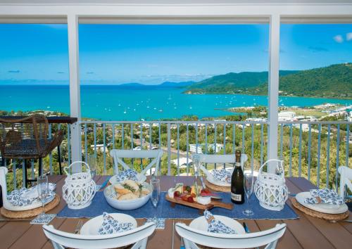 a table with food and a view of the water at South Hamptons Beach House in Airlie Beach