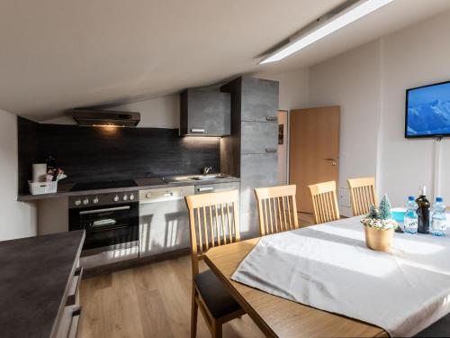 eine Küche mit einem Tisch und eine Küche mit einem Herd in der Unterkunft Apartment Alpenchalets - ZSE203 by Interhome in Zell am See