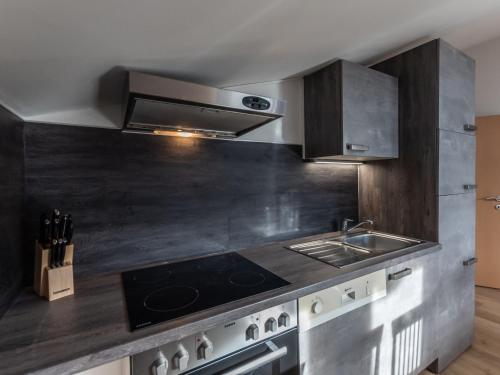 a kitchen with a stove and a sink at Apartment Alpenchalets-4 by Interhome in Zell am See