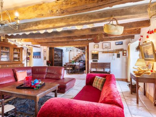 ein Wohnzimmer mit roten Sofas und einem Tisch in der Unterkunft Holiday Home La Duchesse - RHU352 by Interhome in Sarzeau