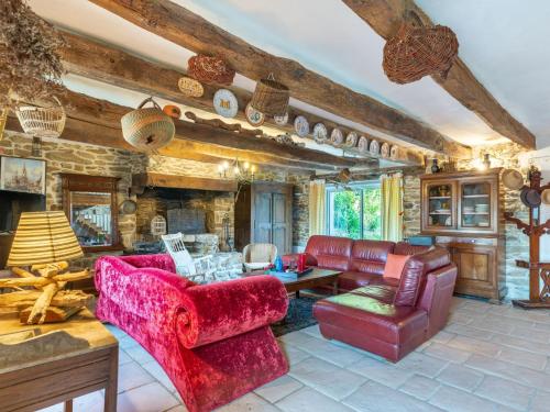 Elle comprend un salon doté d'un mobilier rouge et d'un mur en pierre. dans l'établissement Holiday Home La Duchesse by Interhome, à Sarzeau