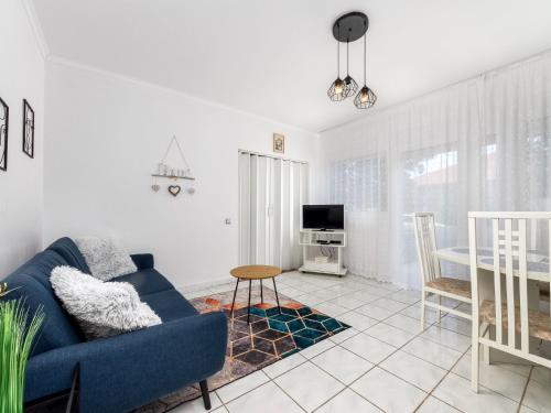 ein Wohnzimmer mit einem blauen Sofa und einem Tisch in der Unterkunft Holiday Home Brasse by Interhome in Balatonkeresztúr
