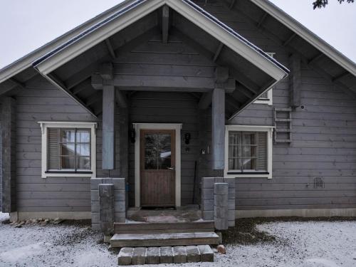 ein Holzhaus mit einer Tür und Fenstern in der Unterkunft Holiday Home Ihtingin koskikara by Interhome in Ruka
