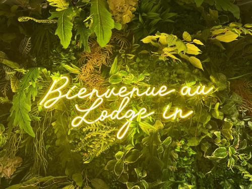 a neon sign that says beware of explorer in a group of plants at Hôtel Lodge In Paris 13 in Paris