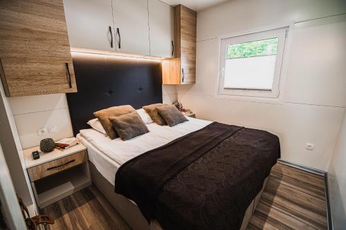 a small bedroom with a bed and a window at Premium Mobile Homes with thermal riviera tickets in Čatež ob Savi