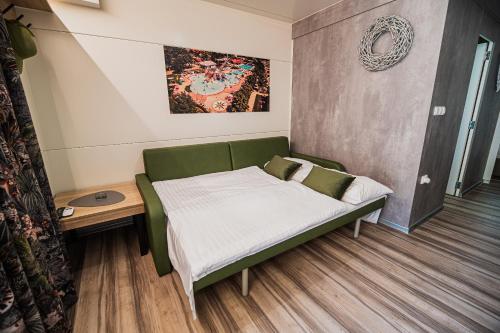 a bed in a room with a green couch at Premium Mobile Homes with thermal riviera tickets in Čatež ob Savi
