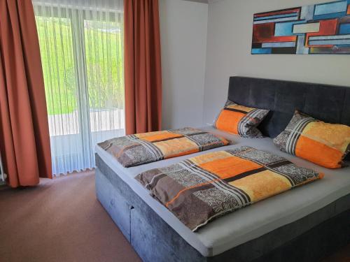 ein Bett mit Kissen darauf im Schlafzimmer in der Unterkunft Pension Haus Inge in Zwiesel