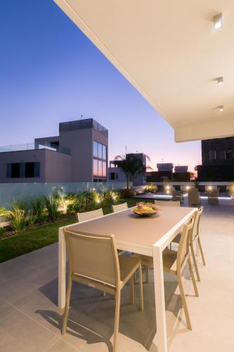 a white dining table and chairs on a patio at Sea Pearl Beachfront Villas - Breeze in Ayia Napa