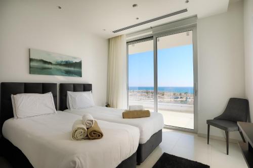 two beds in a room with a view of the ocean at Sea Pearl Beachfront Villas - Breeze in Ayia Napa