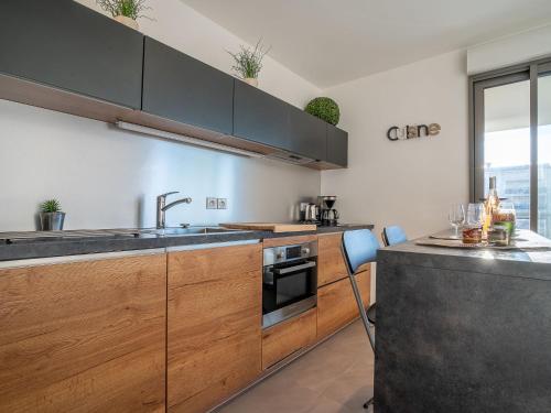 une cuisine avec des armoires en bois et un évier dans l'établissement Apartment Rive Gauche by Interhome, à Fréjus