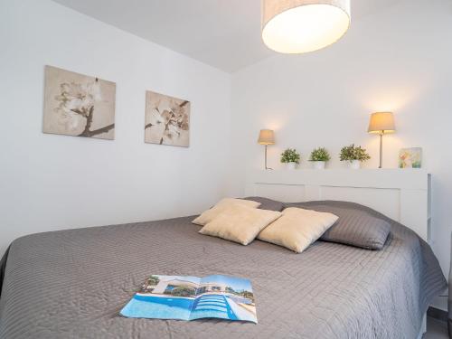 ein Schlafzimmer mit einem Bett mit einem Buch darauf in der Unterkunft Apartment Rive Gauche by Interhome in Fréjus