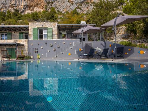uma grande piscina com cadeiras e guarda-sóis em Villa 2M by Interhome em Kotišina