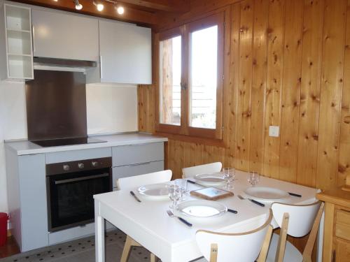eine Küche mit einem weißen Tisch und weißen Stühlen in der Unterkunft Holiday Home Les Farfadets by Interhome in Saint-Gervais-les-Bains