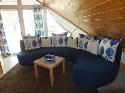 a living room with a blue couch and a table at Ferienwohnung Schmitz in Anschau