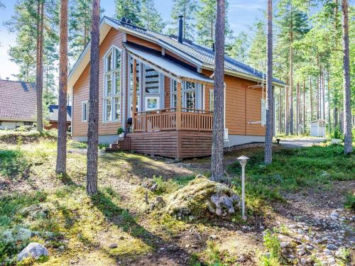 una pequeña casa con un porche en el bosque en Holiday Home Kolinpilvi by Interhome, en Kolinkylä