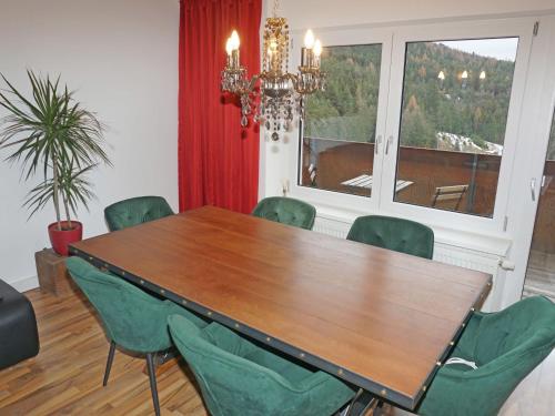 a dining room with a wooden table and green chairs at Apartment Isolde by Interhome in Reith bei Seefeld