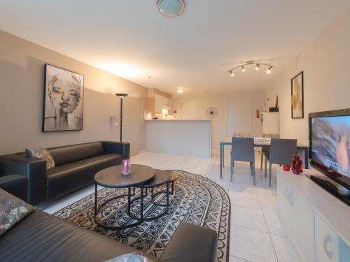 ein Wohnzimmer mit Sofa und Tisch in der Unterkunft Apartment De vakantieduinen aan zee by Interhome in Mispelburg