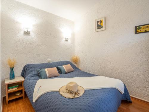 - une chambre dotée d'un lit bleu avec un chapeau dans l'établissement Apartment Résidence Les Jardins d'Azur-2 by Interhome, à Saint-Raphaël