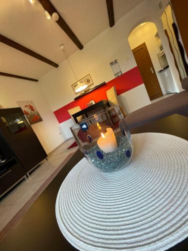 a candle in a glass vase sitting on a table at Apartment Ferienpark Himmelberg-4 by Interhome in Thalfang