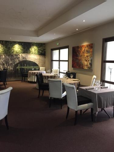 une salle à manger avec tables, chaises et fenêtres dans l'établissement Au Lavoir, à Colombiers