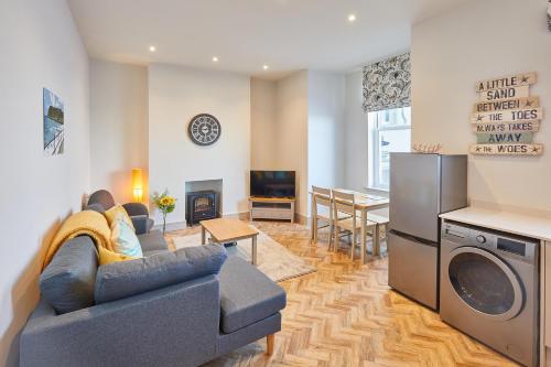 a living room with a couch and a tv and a kitchen at Host & Stay - 2 Maritime Apartments in Scarborough