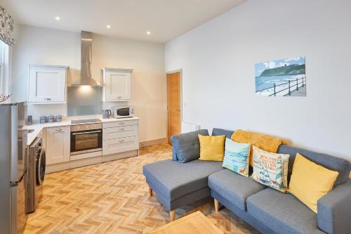 a living room with a couch and a kitchen at Host & Stay - 2 Maritime Apartments in Scarborough