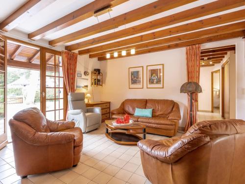 a living room with leather chairs and a table at Holiday Home Marguerite by Interhome in Capbreton