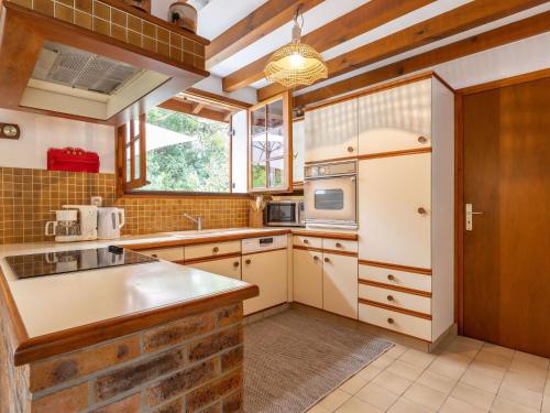 a kitchen with white appliances and a brick wall at Holiday Home Marguerite by Interhome in Capbreton