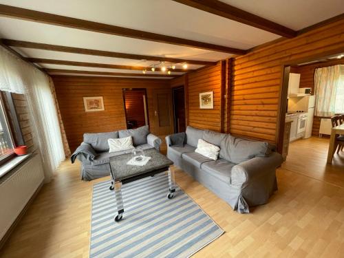 a living room with two couches and a table at Holiday Home Ferienpark Himmelberg-5 by Interhome in Thalfang