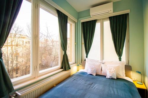 ブダペストにあるSmall Parisのベッドルーム1室(青いベッド1台、窓2つ付)