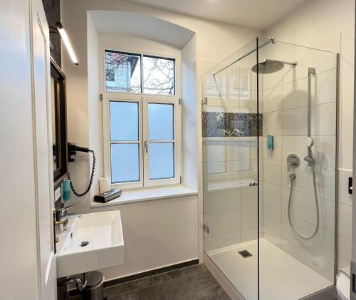 a bathroom with a sink and a shower and a window at Villa Maria - Suiten & Appartement in Kufstein