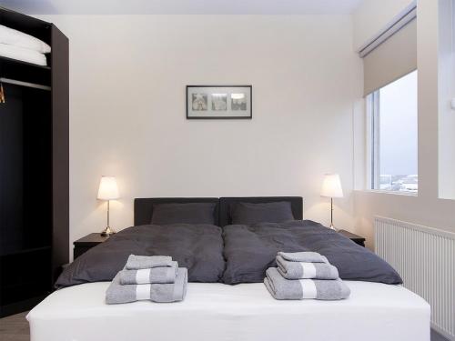 een slaapkamer met een bed met twee handdoeken erop bij KEF Guesthouse by Keflavík airport in Keflavík