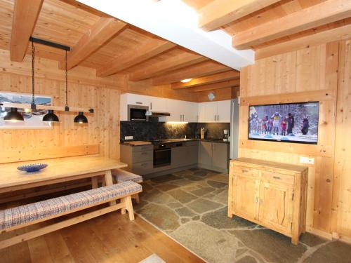 a large kitchen with wooden walls and a flat screen tv at Chalet Chalet Elisabeth by Interhome in Juns