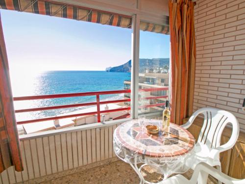 een tafel en stoelen op een balkon met uitzicht op de oceaan bij Apartment Liberty-1 by Interhome in Calpe
