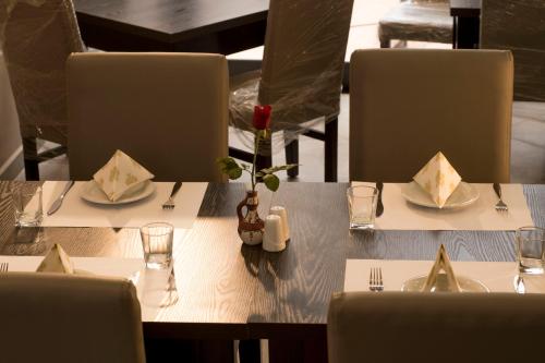 Rouiba的住宿－Hotel Bournissa，餐厅里一张带盘子和餐具的桌子