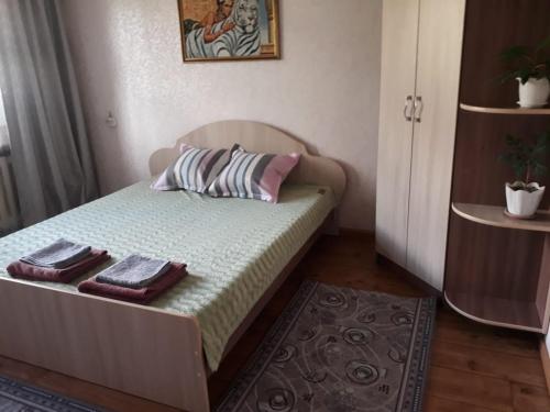 a small bedroom with a bed with two towels on it at Аппартоменты in Shchūchīnsk