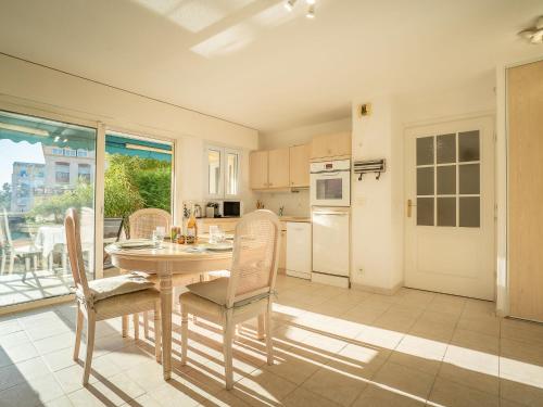 une salle à manger avec une table et des chaises et une cuisine dans l'établissement Apartment L'Escale by Interhome, à Fréjus