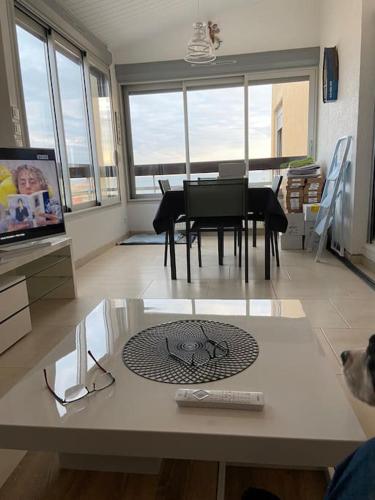 - un salon avec une table et une salle à manger avec vue dans l'établissement Appartement Cap d Agde Magnifique vue mer, au Cap d'Agde