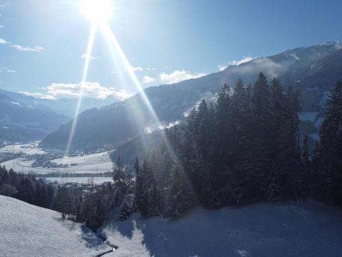 a sun shines on a mountain with snow and trees at Apartment Sonnigs Platzl by Interhome in Stumm