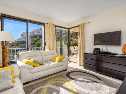 ein Wohnzimmer mit einem weißen Sofa und einem TV in der Unterkunft Apartment Cielo y mar Samara-1 by Interhome in Marbella
