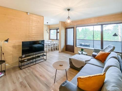 a living room with a couch and a flat screen tv at Holiday Home The cozy loggers suite by Interhome in Salla