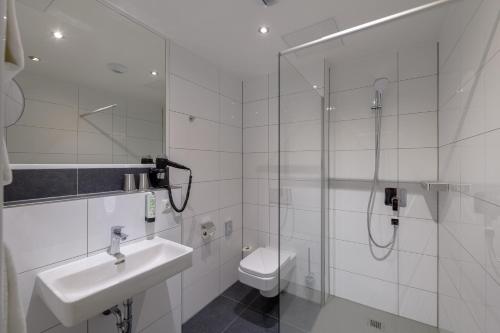 a bathroom with a shower and a sink and a toilet at Panorama Hotel Schweinfurt in Schweinfurt
