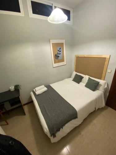 a bedroom with a large white bed with a black blanket at Center Madrid habitaciones in Madrid