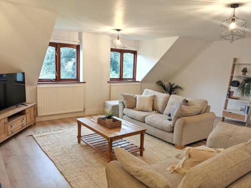 a living room with two couches and a coffee table at Seaside Cottage, 8min walk to beach. Dog friendly. in Norwich