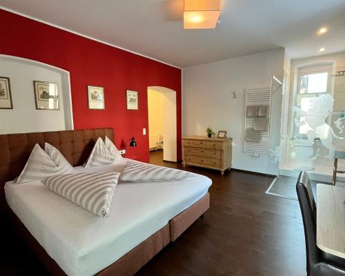 a bedroom with a bed with a red wall at Villa Maria - Suiten & Appartement in Kufstein