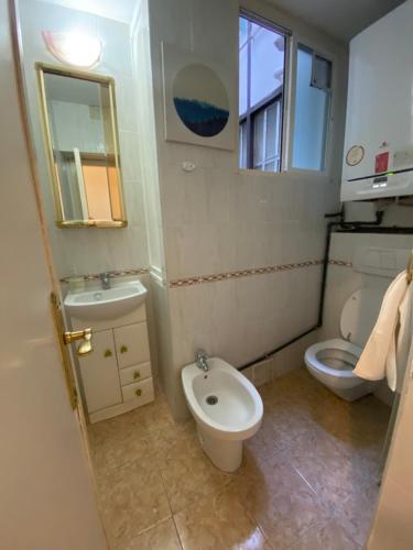 Baño pequeño con aseo y lavamanos en Center Madrid habitaciones en Madrid