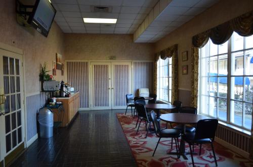 a dining room with tables and chairs and windows at Travel Inn in Birmingham